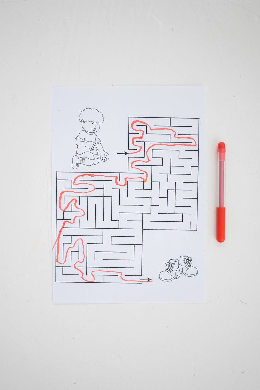 kids worksheet with solved maze placed on table with pen