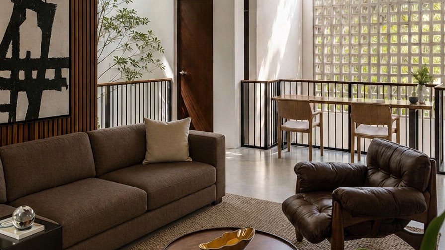 Upper family area at the Bangi house with leather lounge chairs and a glass-block wall